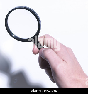 Male hand holding magnifying glass Banque D'Images