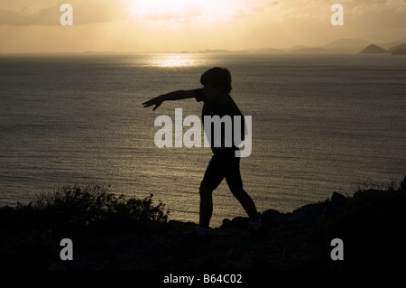 Silhouette de garçon en train de lancer un rocher St. John USVI Banque D'Images