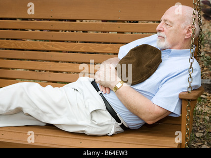 Man une sieste dans un parc swing Banque D'Images