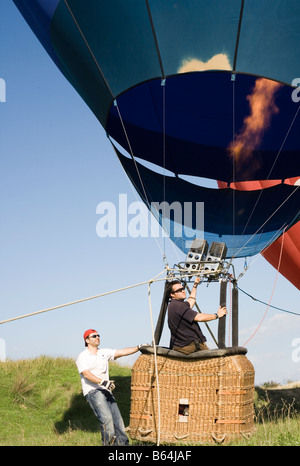 Torremolinos Costa del Sol Malaga Province Espagne Man filling hot air balloon à l'aide de brûleurs au propane la préparation pour le vol Banque D'Images