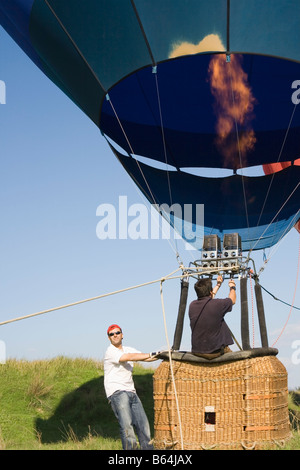 Torremolinos Costa del Sol Malaga Province Espagne Man filling hot air balloon à l'aide de brûleurs au propane la préparation pour le vol Banque D'Images