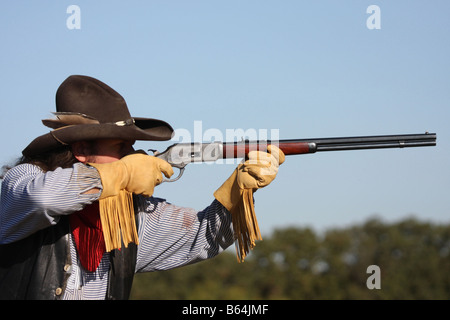 Un cowboy prenant but avec son fusil à cheval dans l'ouest Banque D'Images