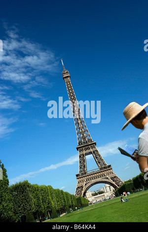 France, Paris, Tour Eiffel, Woman Reading guide book Banque D'Images