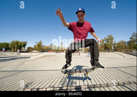 Jeune homme de faire un tour à un skate park Banque D'Images