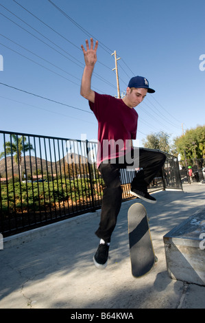 Jeune homme de faire un tour à un skate park Banque D'Images