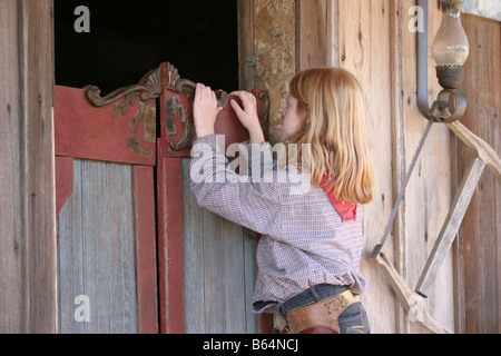 Un jeune cowgirl essayant d'oeil dans un saloon dans le Vieil Ouest Banque D'Images