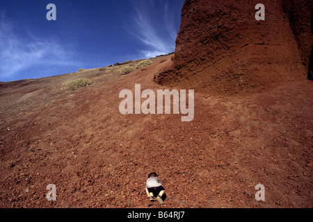 Petit enfant de grimper des pentes volcaniques au Parc National de Timanfaya, Lanzarote, Espagne Banque D'Images