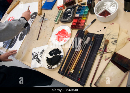 Un artiste se prépare à travailler avec ses peintures et pinceaux. Banque D'Images