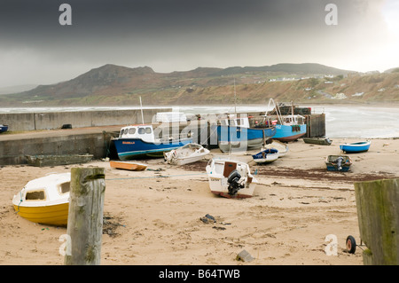 Bateaux de pêche sur le sable à marée basse de Nefyn Porth Gwynedd au nord du Pays de Galles sous un ciel d'orage, automne hiver, UK Banque D'Images