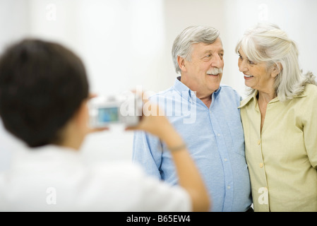 Senior couple photographié par petit-fils, smiling at each other Banque D'Images
