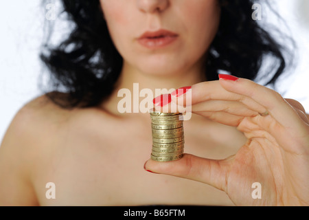 Modèle est une pile de pièces d'une livre entre les doigts Banque D'Images