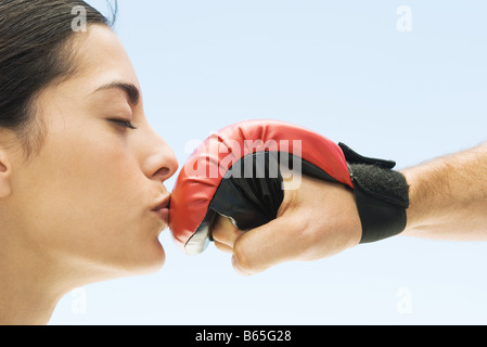 Woman kissing man's boxing glove, yeux clos, side view Banque D'Images