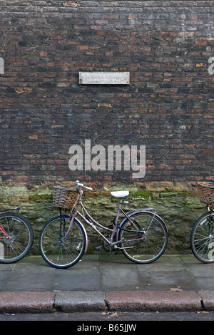 Les vélos s'appuyer contre un mur, à Cambridge, un signe dit que 'les vélos ne doivent pas être s'appuya contre le mur' Banque D'Images