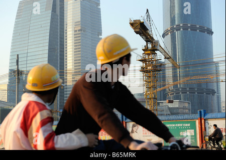 Travailleurs migrants chinois montent leurs location passé un chantier à Guangzhou, Guangdong, Chine. 26-Dec-2008 Banque D'Images
