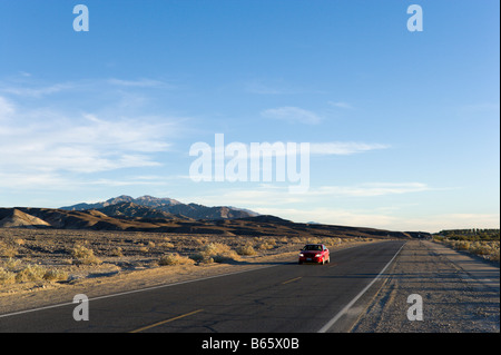 Lone voiture sur SR 190 près de Furnace Creek peu avant le coucher du soleil, la Death Valley National Park, California, USA Banque D'Images