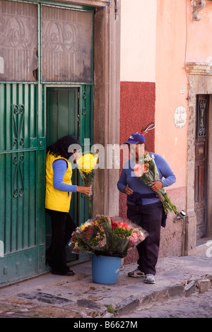 Une fleur le vendeur et l'acheteur dans une rue de San Miguel de Allende, Mexique. Banque D'Images