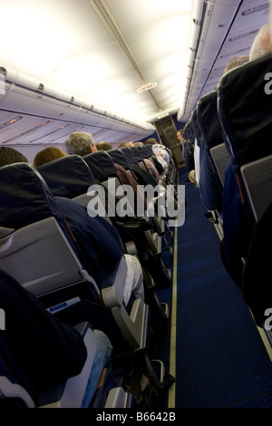 Allée de l'avion avec plein de sièges passagers Banque D'Images