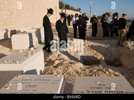 Mont des Oliviers Jérusalem Israël cimetière juif orthodoxe 2 hommes debout au-dessus de deux tombes ouvertes Banque D'Images