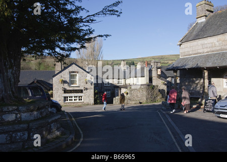 En hiver, les visiteurs à l'extérieur de l'ancienne auberge dans le centre de Widecombe dans le Devon Dartmoor Moor Banque D'Images