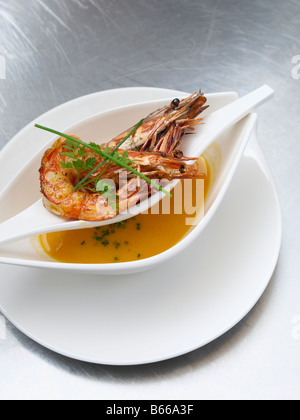 La photographie alimentaire servi avec une soupe de gambas grillées dans un bol double unique sur un plan de travail de cuisine professionnelle en inox Banque D'Images