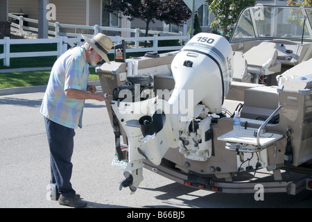 Un homme travaillant sur l'hivernage des moteurs de son bateau Banque D'Images