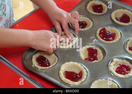 Enfant faisant des tartelettes à la confiture Banque D'Images