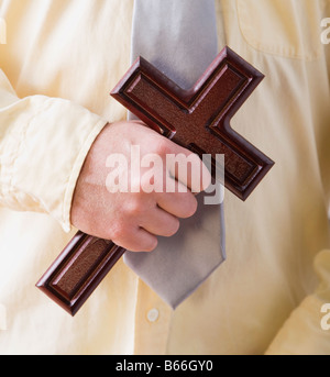 Mid section of man holding croix chrétienne Banque D'Images