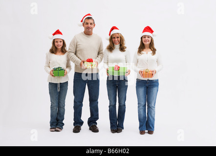 Famille avec deux filles (10-11, 16-17) holding presents dans studio Banque D'Images