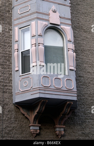 Baie vitrée en bois ornée de corbels en bois qui dépassent du mur d'une ancienne maison du plateau Mont-Royal, Montréal, Québec, Canada Banque D'Images