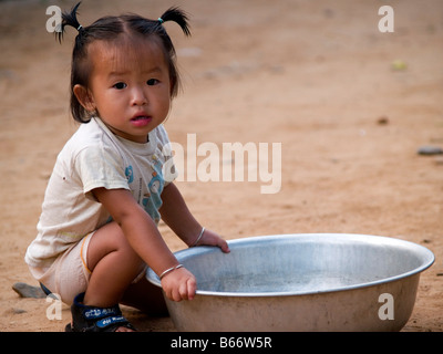 Jolie petite fille et son bassin à Muang Ngoi village dans le nord du Laos Banque D'Images