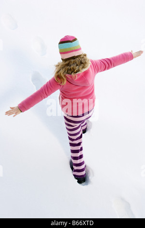 Fille qui marche dans la neige Banque D'Images