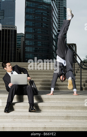 Businessman doing handstand Banque D'Images