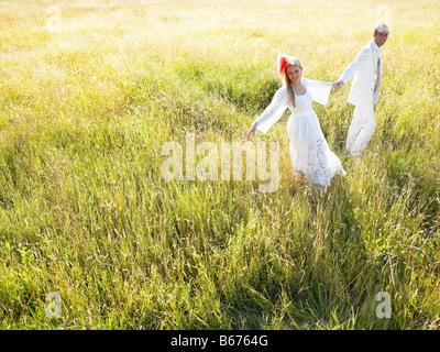 Couple marié de marcher dans un champ Banque D'Images
