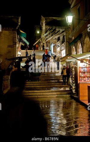 Boutiques sur une rue menant au Pont du Rialto à Venise Italie une nuit pluvieuse en novembre Banque D'Images