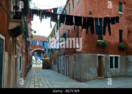 Laundryday à Venise Italie la blanchisserie sont en train de sécher dehors sur les lignes de lavage à travers les rues étroites Banque D'Images