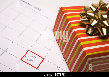 Boîte-cadeau allongé sur le calendrier avec Boxing Day marqué Banque D'Images