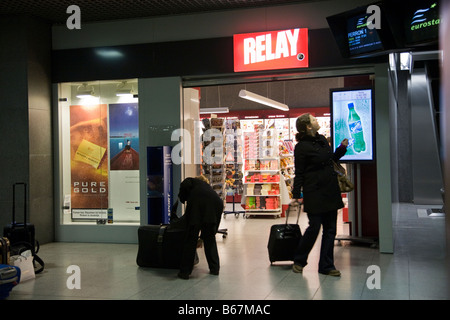 Train Eurostar passagers à l'extérieur de la 'Relay' style duty free shop dans le salon Eurostar de la gare du Midi de Bruxelles, Belgique. Banque D'Images