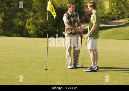 Les golfeurs masculins Shaking Hands Banque D'Images
