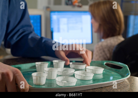 Plateau avec les tasses jetables comprimé à la station de l'infirmière Banque D'Images