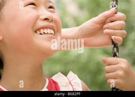 Close-up of a Girl smiling on a swing Banque D'Images