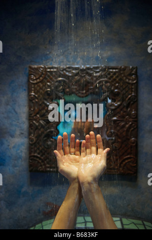 Les mains sous l'eau de douche Banque D'Images