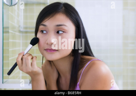 Woman Applying Make-up Banque D'Images