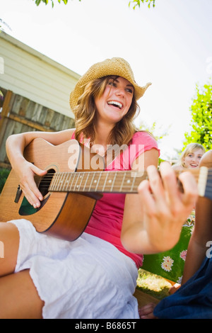 Femme jouant de la guitare à Backyard Barbeque, Portland, Oregon, USA Banque D'Images