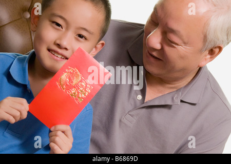 Close-up of a Boy holding a greeting card and smiling Banque D'Images