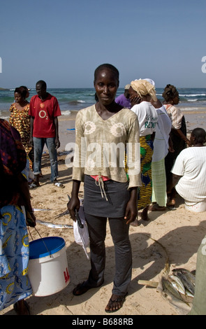 Femme d'acheter le poisson débarqué fraîchement au marché aux poissons, sur la plage à Dakar Yoff Sénégal Banque D'Images