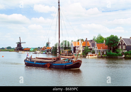 Bateau traditionnel néerlandais dans l'eau près de moulin en Hollande, Pays-Bas Banque D'Images