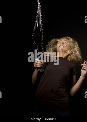 Femme jetant de l'eau dans un verre Banque D'Images