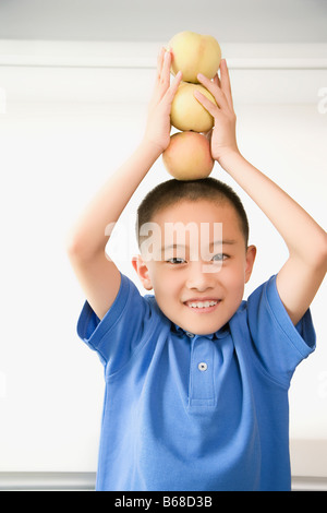 Portrait of a Boy balancing pommes sur sa tête Banque D'Images