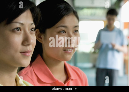 Close-up of two female office workers looking away Banque D'Images