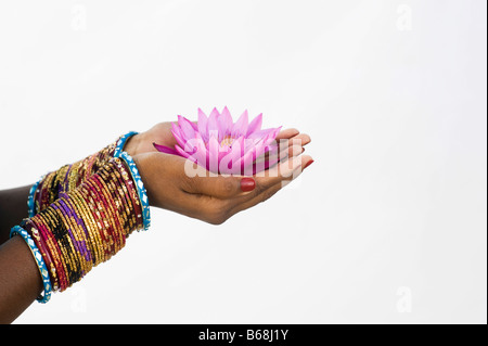 Femme indienne offrant un Nymphaea nénuphar Tropical flower in her creux des mains. L'Inde Banque D'Images